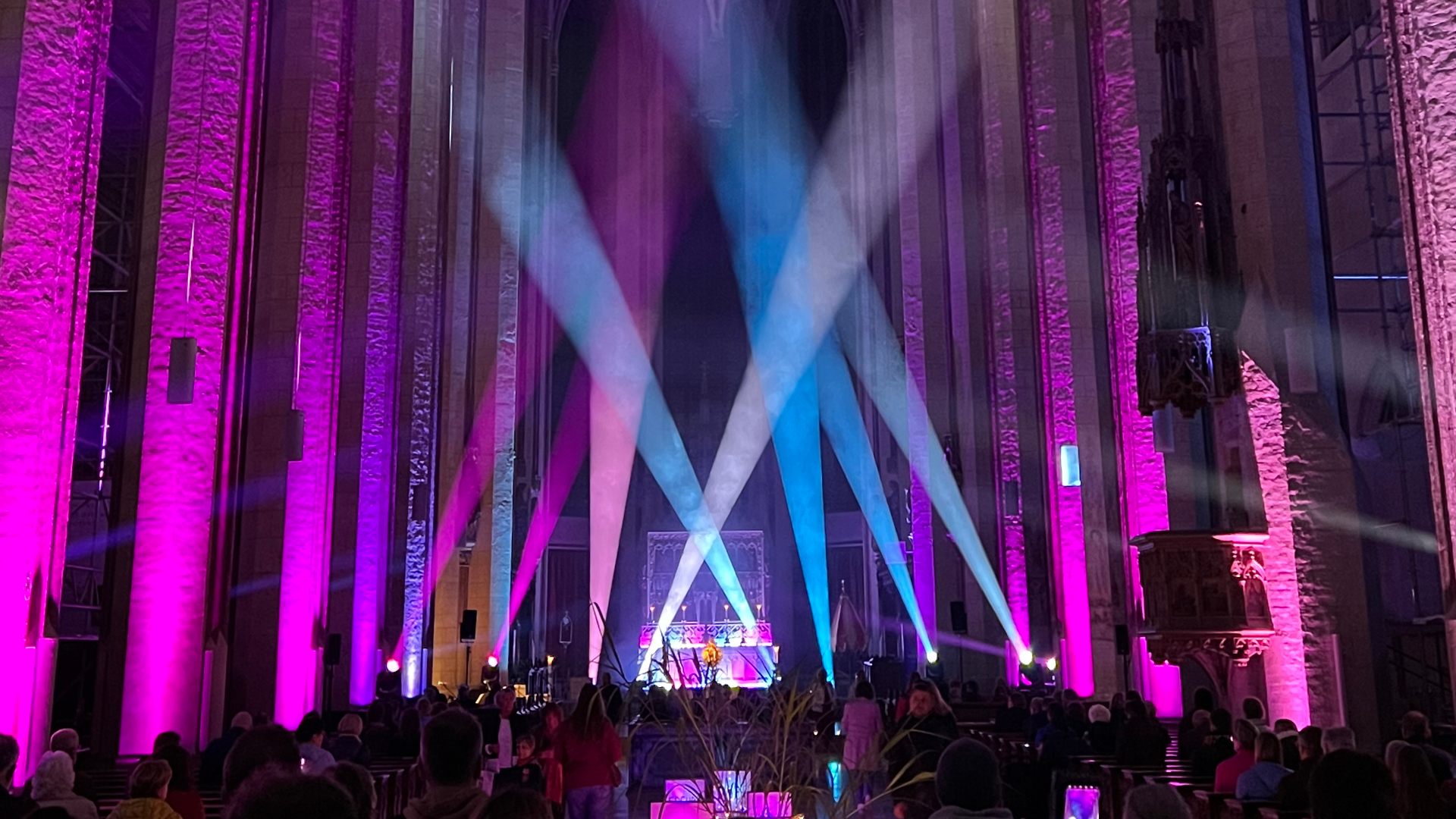 Kathedrale mit gekreuzten pinken und blauen Lichtstrahlen vor dem Altar
