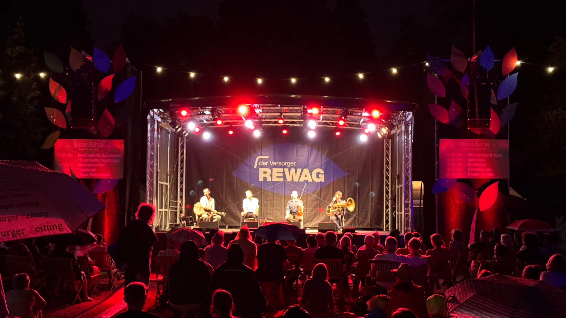 Open-Air-Bühne bei Nacht mit rotem Bühnenlicht vor Publikum